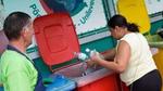 A woman placing plastic bottles in a recycling bin