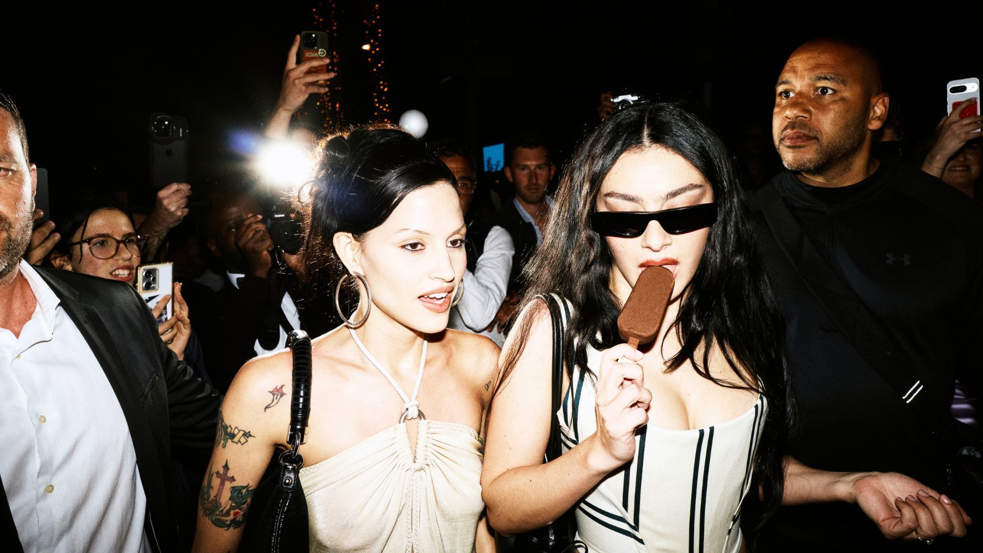 A girlfriend talks to Charli xcx as she walks along eating a classic milk chocolate Magnum ice cream