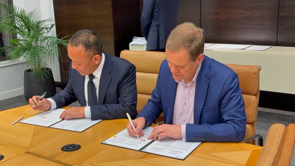 A photograph of Unilever's Chief Supply Chain and Operations Officer signing a long-term partnership with PT. Perkebunan Nusantara to source sustainable palm oil.