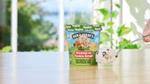 Ben & Jerry’s non-dairy Cookies on Cookie Dough tub with new oat base and a hand holding a smooth rich spoonful