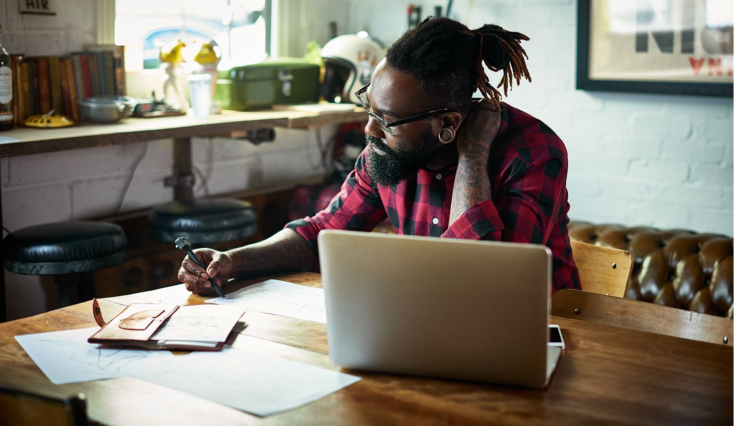 Man with beard working at laptop. Unilever Flex Experience matches people with projects that offer the chance to upskill.