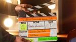 Hands operating a clapperboard