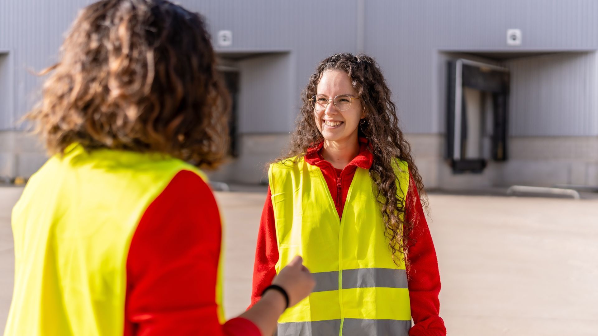 Two women dressed in high-visibility clothing having a conversation