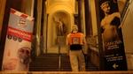Cleaner wearing protective clothing and carrying a Lysoform spray backpack walking up steps in one of Italy’s main museums.