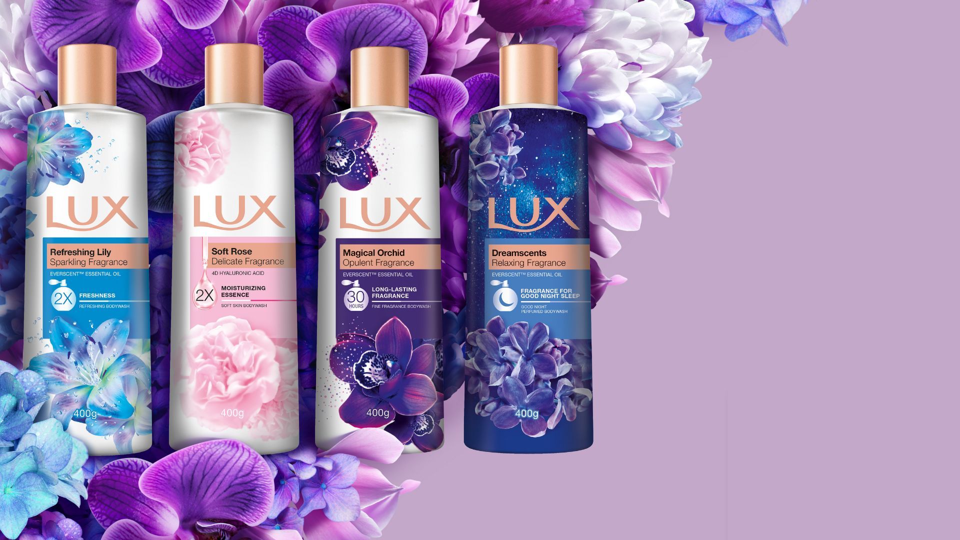 Four bottles of LUX bodywash on a bed of flowers. The bed of flowers is resting on a lavender background.