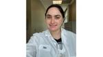 A photo of a scientist who worked on the Vaseline Verified campaign. A white woman with brown hair, in a lab coat.