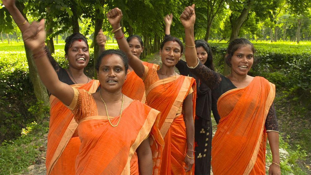 Photo of six women with arms raised in the air