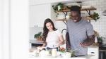Two people cooking together cheerfully