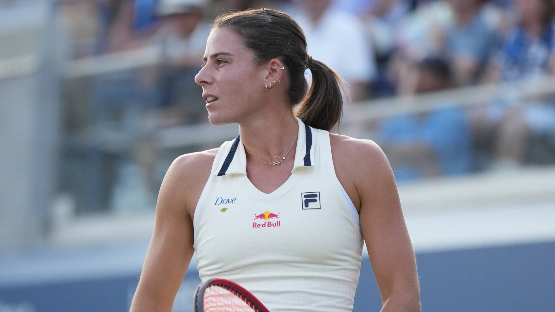 Tennis player Emma Navarro competes wearing a white outfit with a Dove logo on her right shoulder