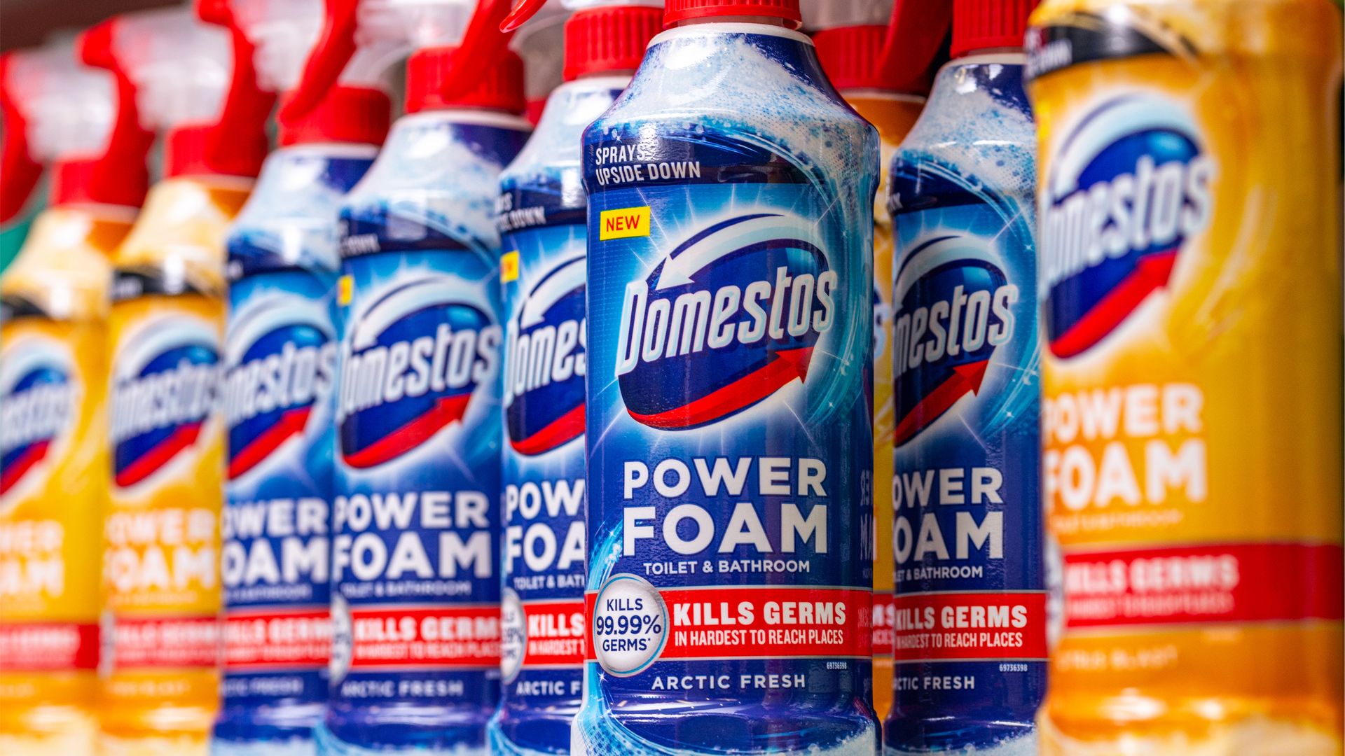 A selection of Domestos Power Foam products on a supermarket shelf.