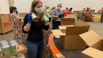 A photo of Unilever employees packing boxes for the United for America initiative