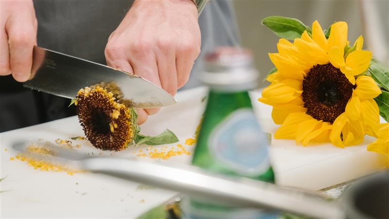 Close-up of a sunflower being sliced before being cooked.