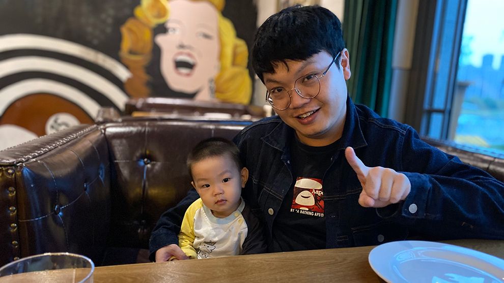 Image of man pointing to camera and child