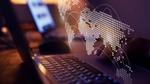 Close-up of a laptop keyboard with a digital world map overlay, featuring dotted continents and curved lines representing global connections, against a blurred background.