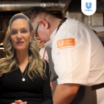 A person in a black top is overlaid on an image of a professional kitchen, where a chef wearing a white coat with an orange Unilever Food Solutions logo and a grey apron is working. The Unilever logo appears in the top-right corner.
