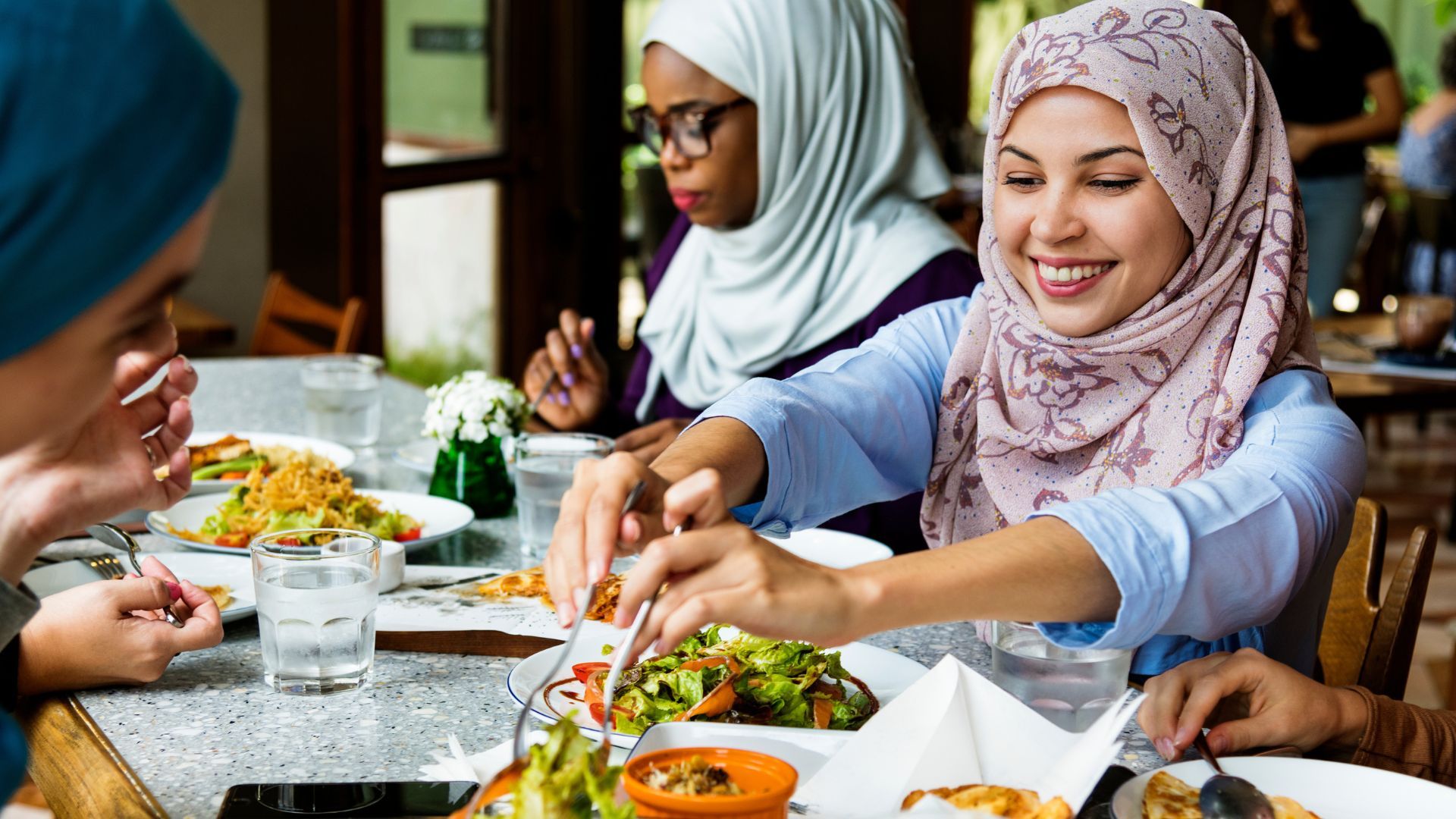 Ladies sitting at a table, eating and sharing food