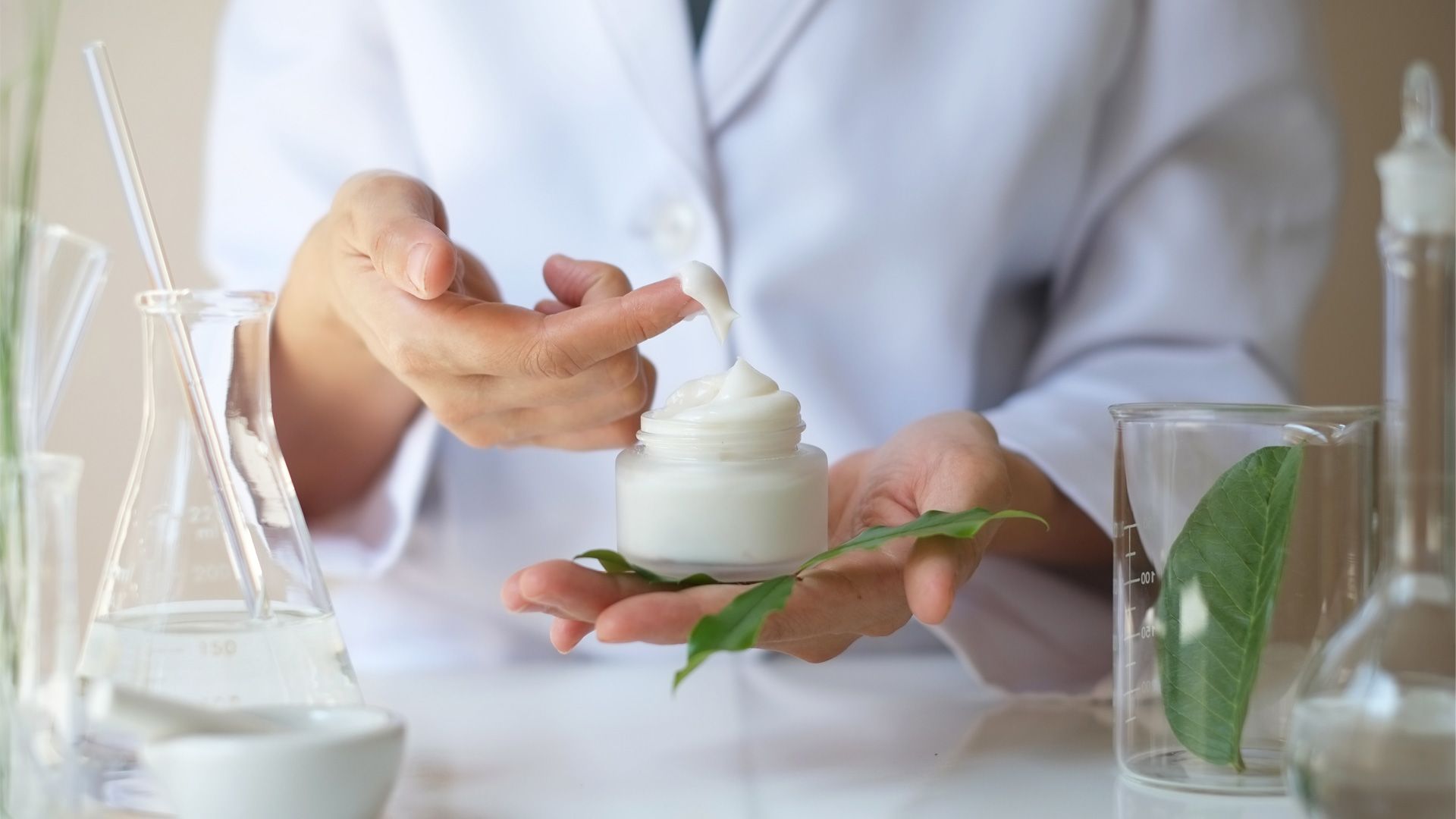 A person holding a jar of cream