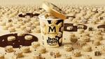 A tub of White Chocolate & Cookies Magnum Bon Bon with an open lid. The tub is surrounded by Bon Bon pieces.