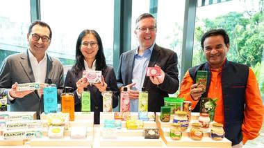 Unilever International CEO Aseem Puri with team members in front of a table of products including Pears soap and Bru coffee.