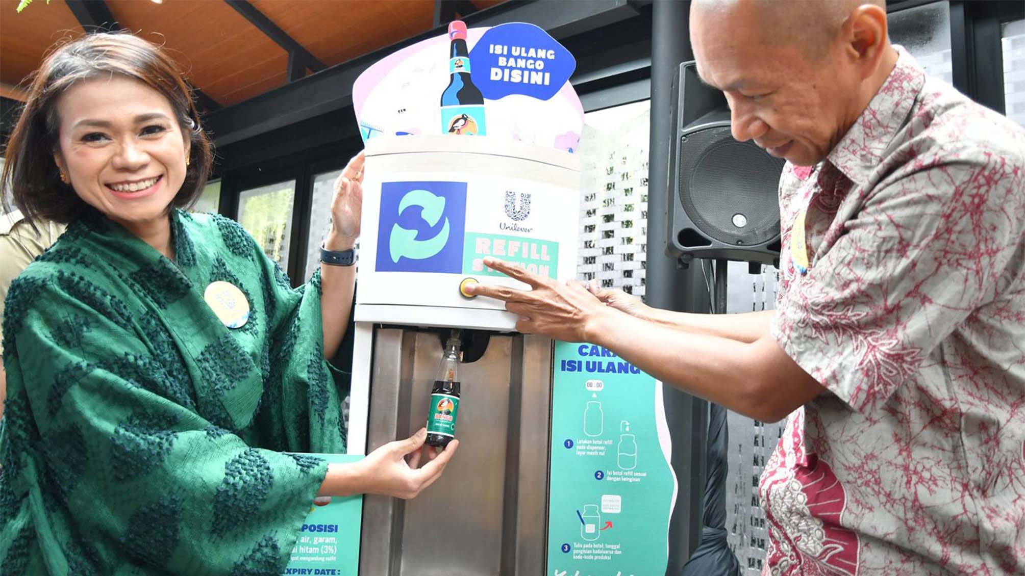 Woman and man using a refill station for Bango soy sauce in the Saruga packaging-free store in Bintaro, Indonesia.