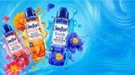Three Comfort Fresh Scent Booster Elixir bottles with flowers and splashes on a blue background