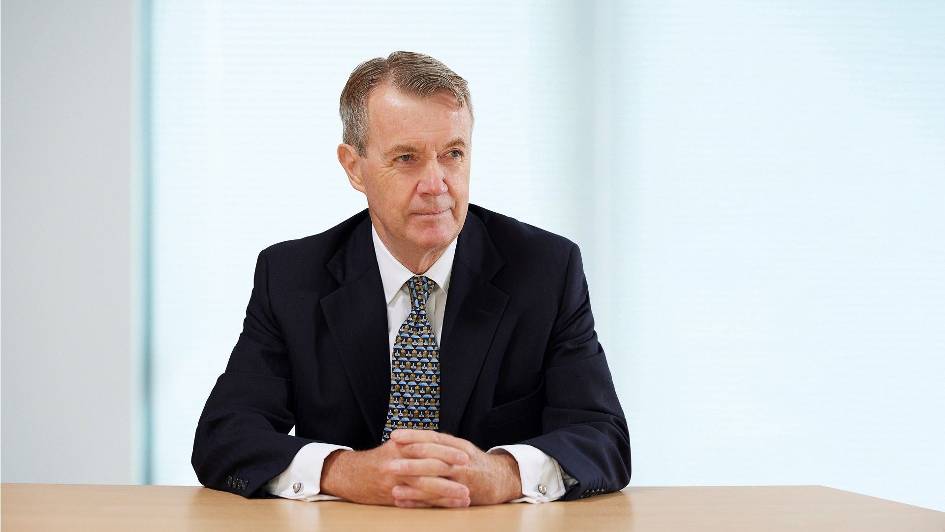 Ian Meakins, Chair Designate of Unilever, sitting at a desk wearing a dark jacket and patterned tie.