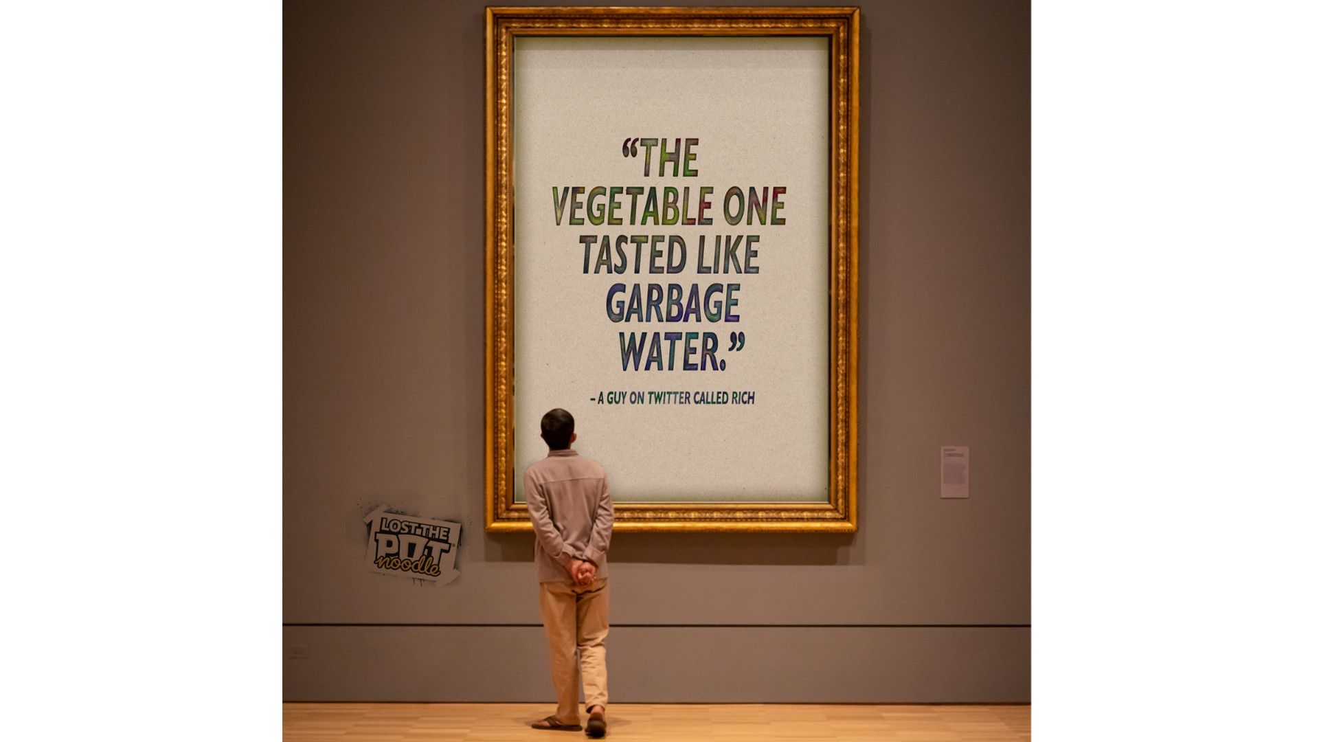 Image of a man standing in front of a large poster with a comment about ‘Lost the Pot’ Noodles saying, ‘The vegetable one tasted like garbage water’