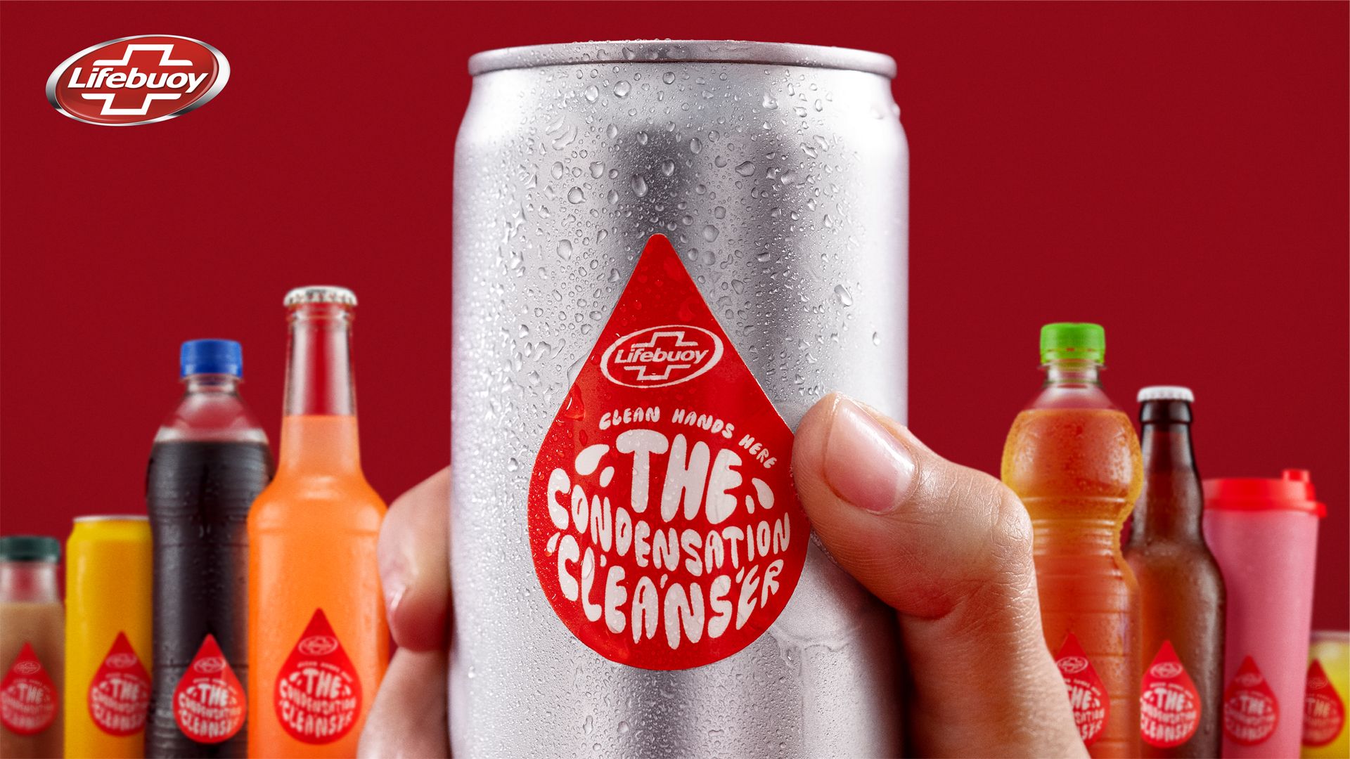 A drink can is being held in the foreground with a sticker that says: “The Condensation Cleanser”. In the background, a variety of other drinks containers – plastic bottles, glass bottles, cans and reusable cups – all display the same sticker.