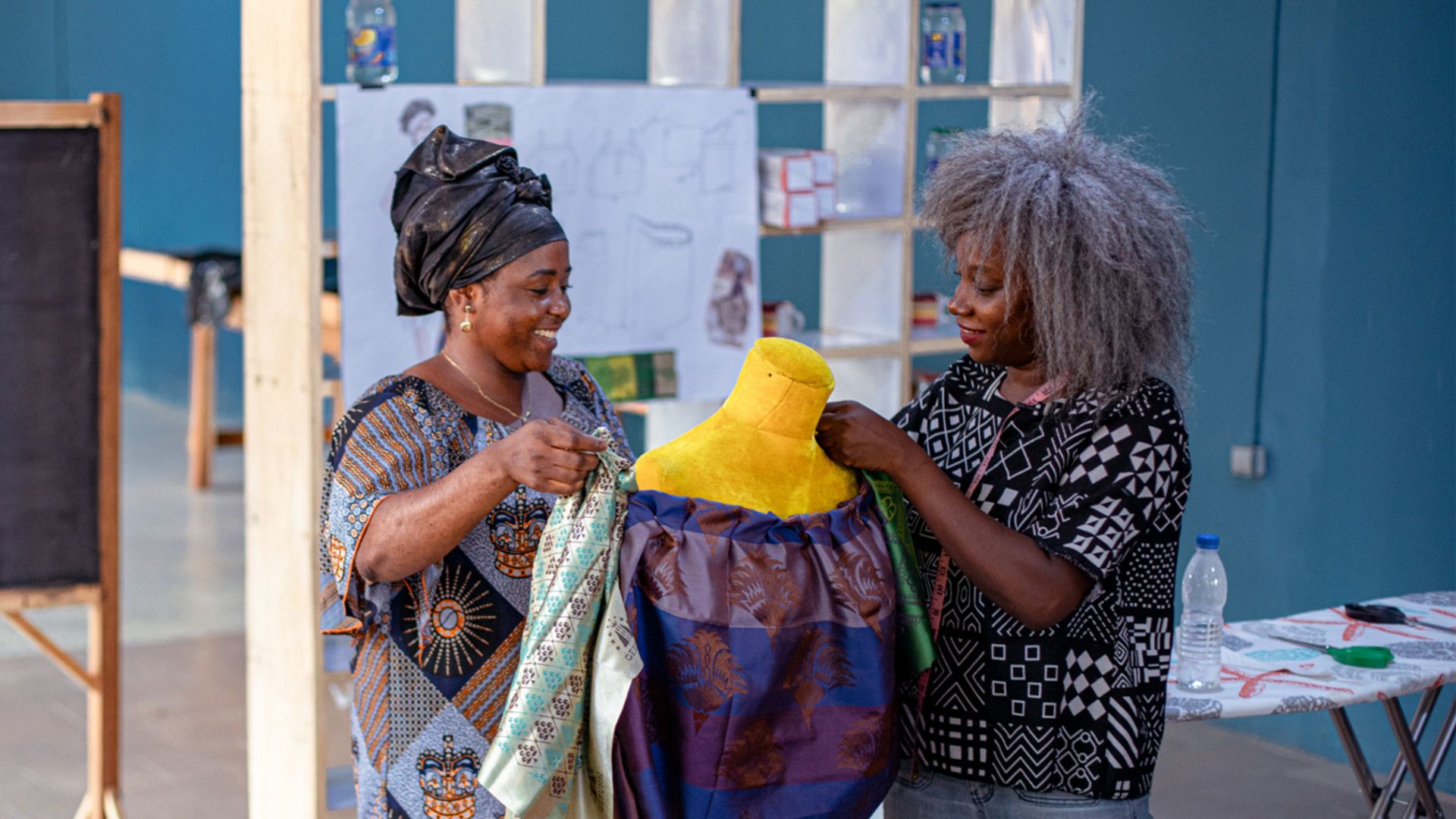 Fashion designer Rebecca Zoro, AWA By Magnum course mentor, discussing a garment with a student in the classroom 