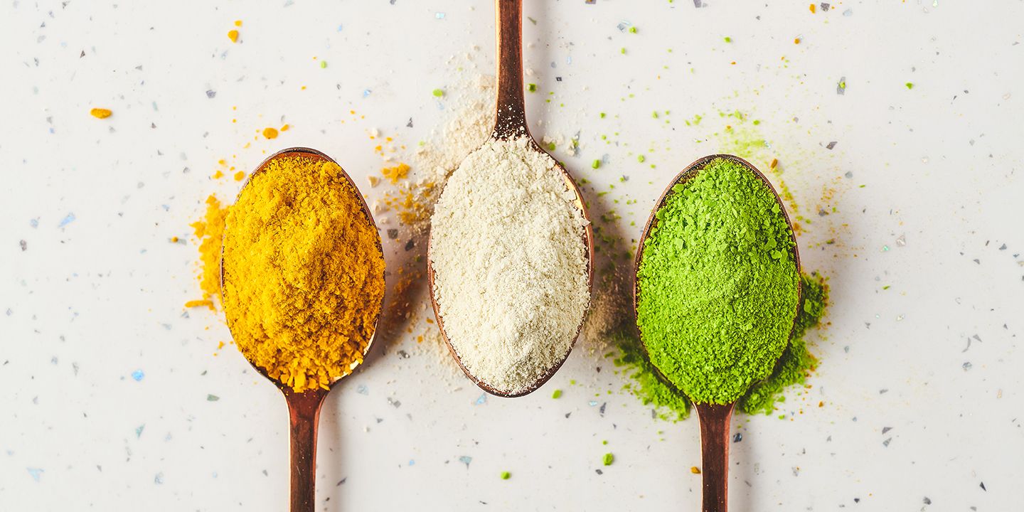 Three spoons holding the yellow, white and green variants of Algenuity’s microalgae rich protein powder