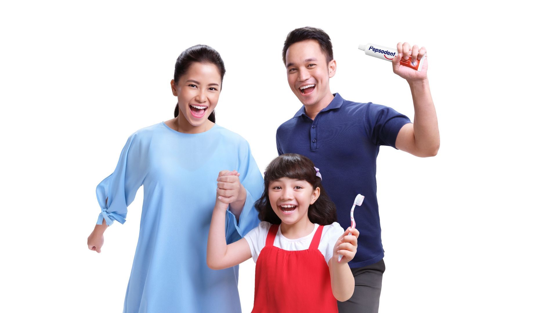 A happy family of two parents and one child. The child is holding the mum’s hand in one hand and a toothbrush in the other, while the dad is holding a tube of Pepsodent toothpaste.
