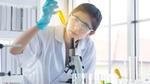 A scientist looking at a test tube