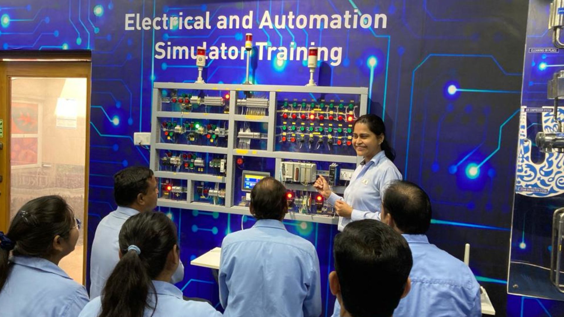 Factory team members in blue shirts receiving training in 4th Industrial Revolution technologies