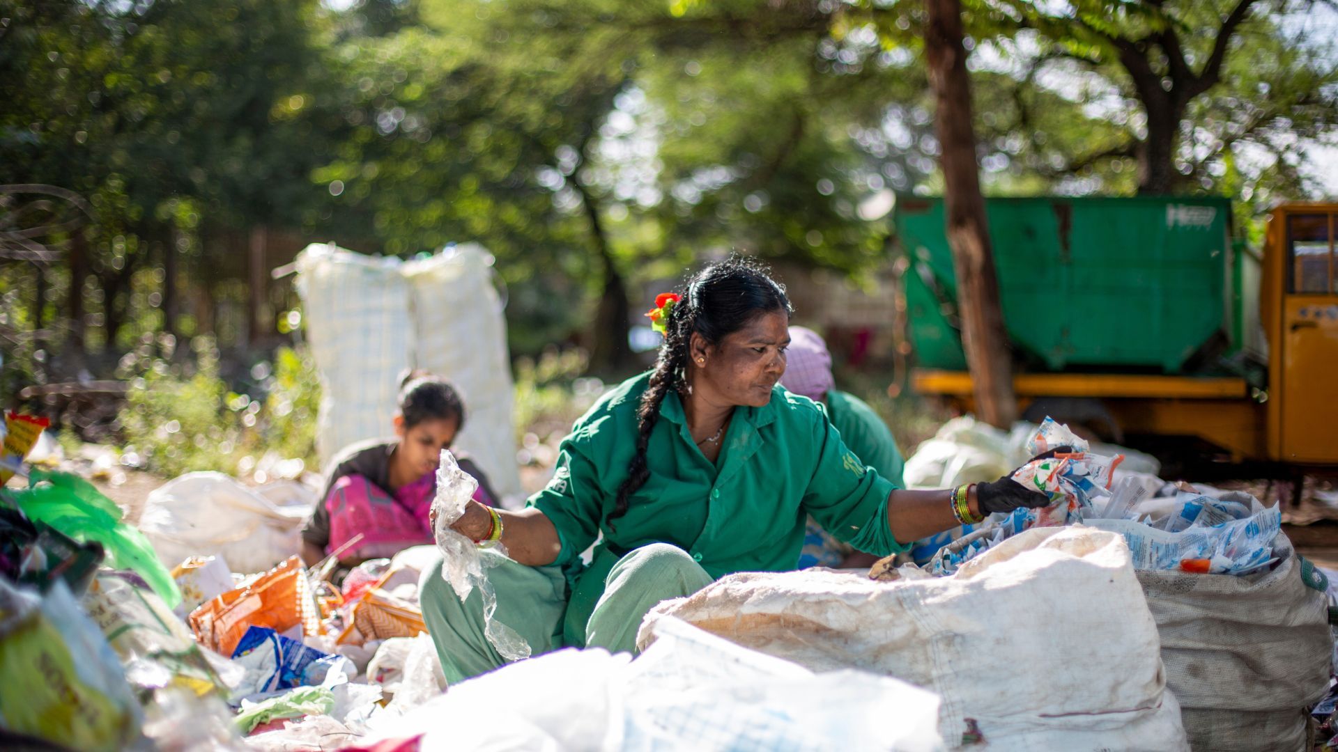 Two women sorting bags of plastic at Hasiru Dala, a social enterprise that enhances the livelihoods of workers in the informal waste sector.