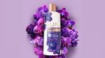 A photo of LUX Magical Orchid shower gel. White bottle surrounded by purple orchid flowers.