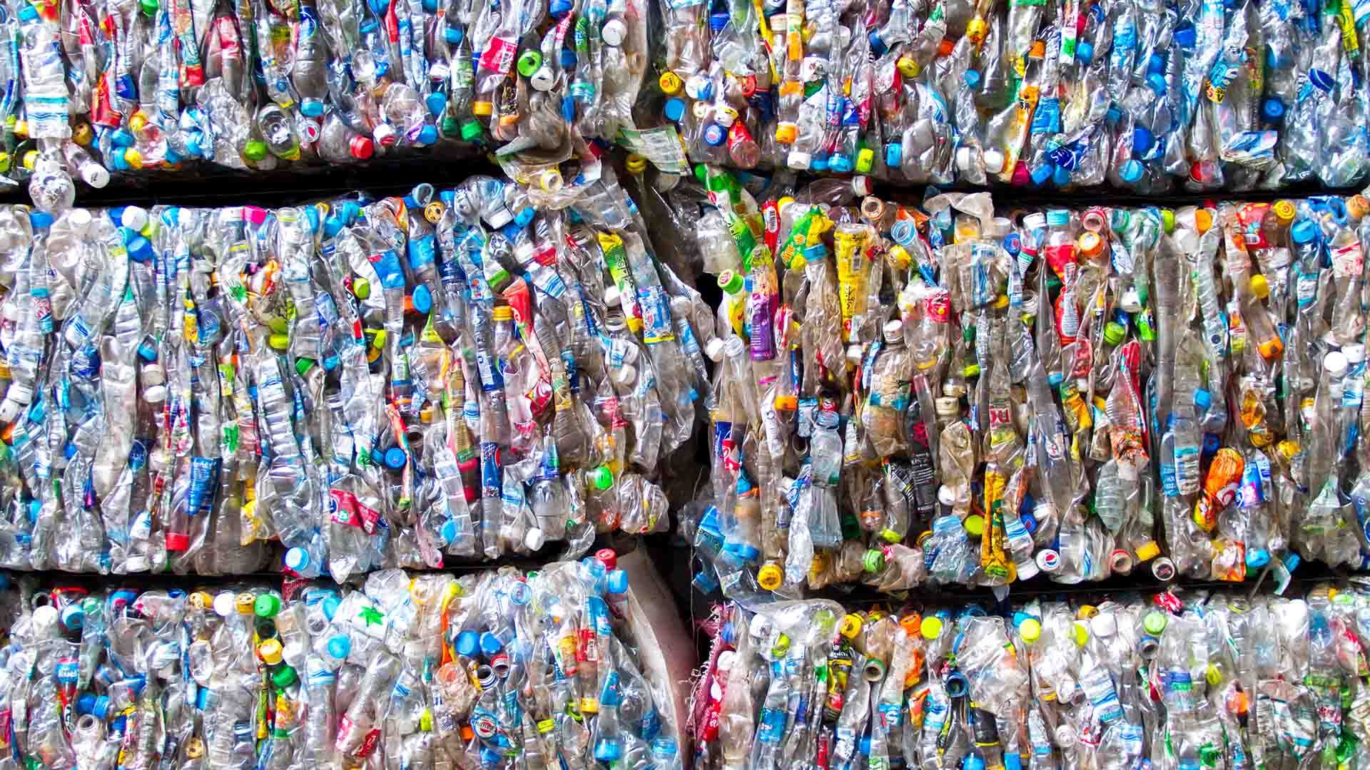 Plastic packaging flattened into six large bales