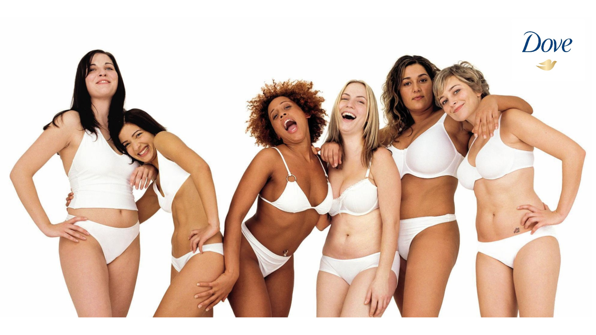 A line of six women in white underwear laughing and smiling at the camera