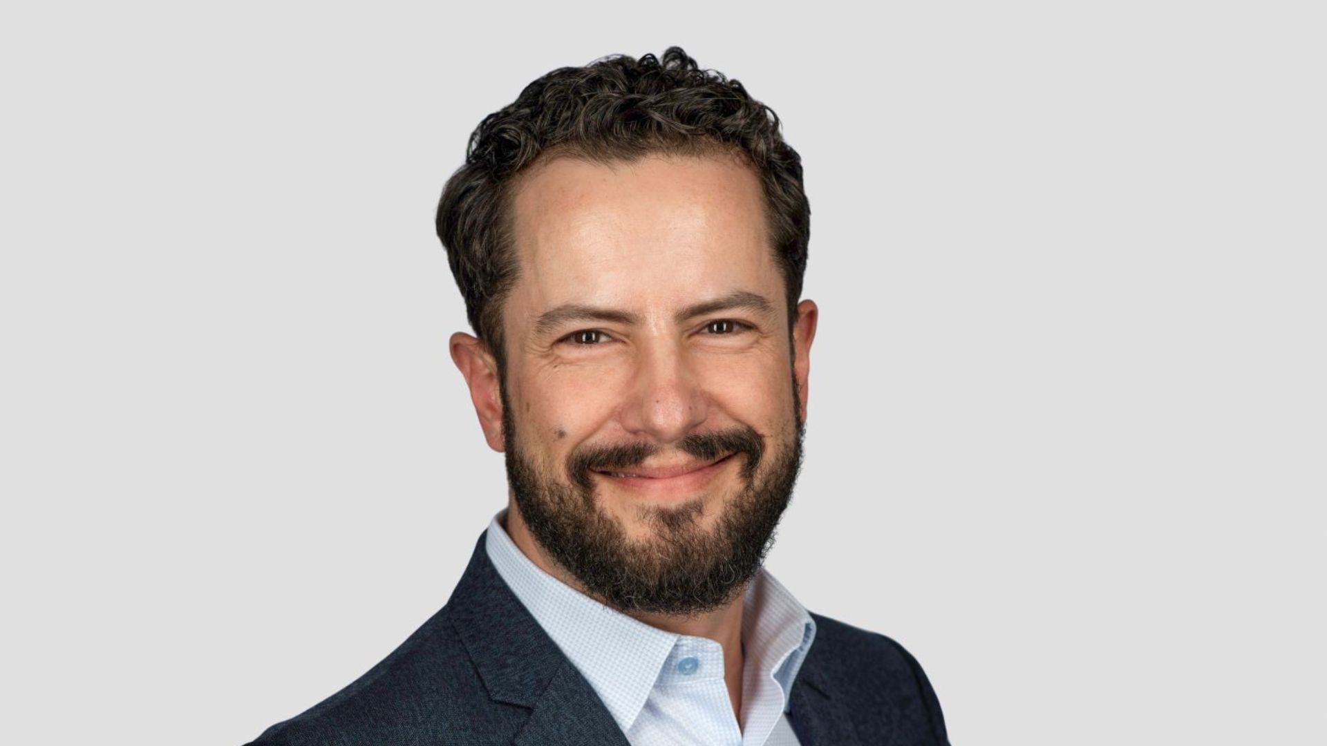 A photo of Leandro Barreto, Chief Marketing Officer for Unilever Beauty & Wellbeing. Leandro is a white man with dark hair and a beard, smiling at the camera.