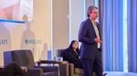 Businessman delivers a presentation on stage at a Barclays corporate event.
