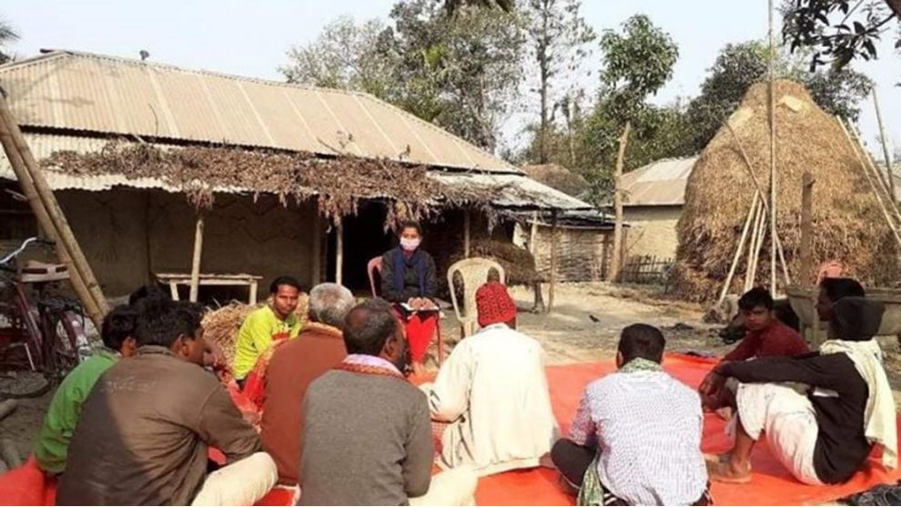 A group of people sitting in a village