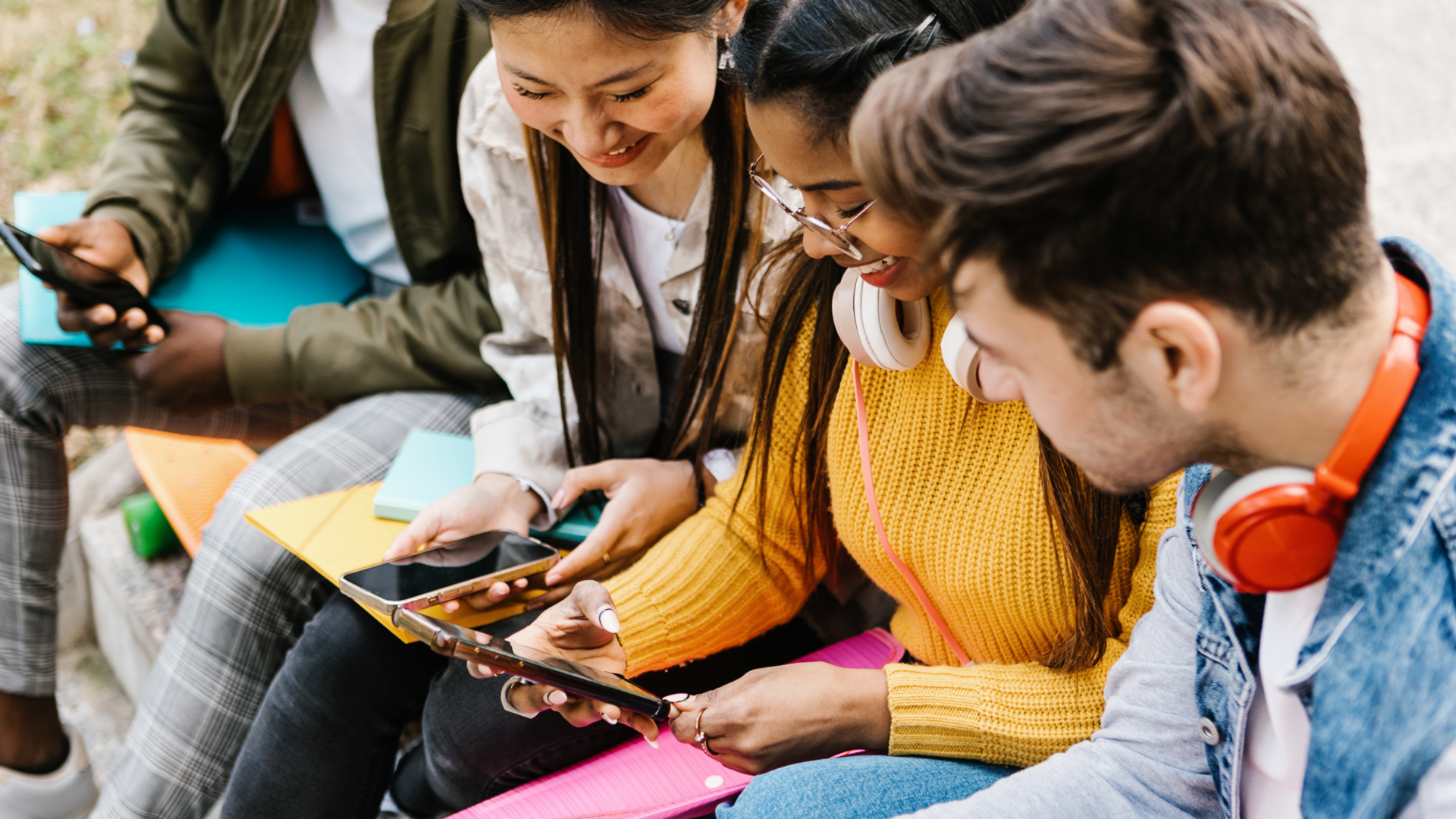 A group of four young adults in colourful clothing using social media to make sustainable choices 