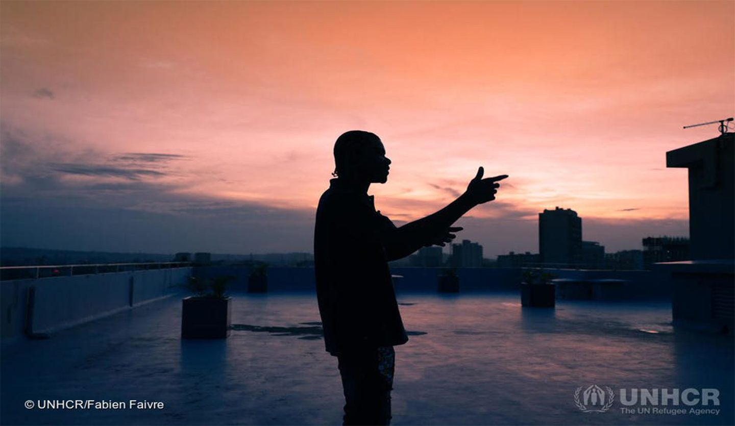 The outline of a man in shadows against the orange light of sunset