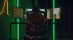 A gamer sits in front of three gaming screens.