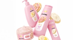 Products from the Dove Crumbl collaboration including Confetti Cake body wash in a pink bottle. Crumbl cookies in background.