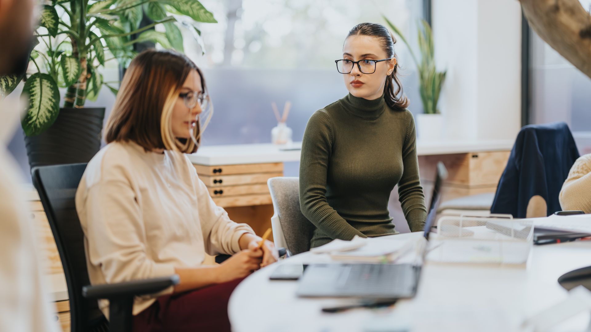 Two younger women chatting in a roundtable format