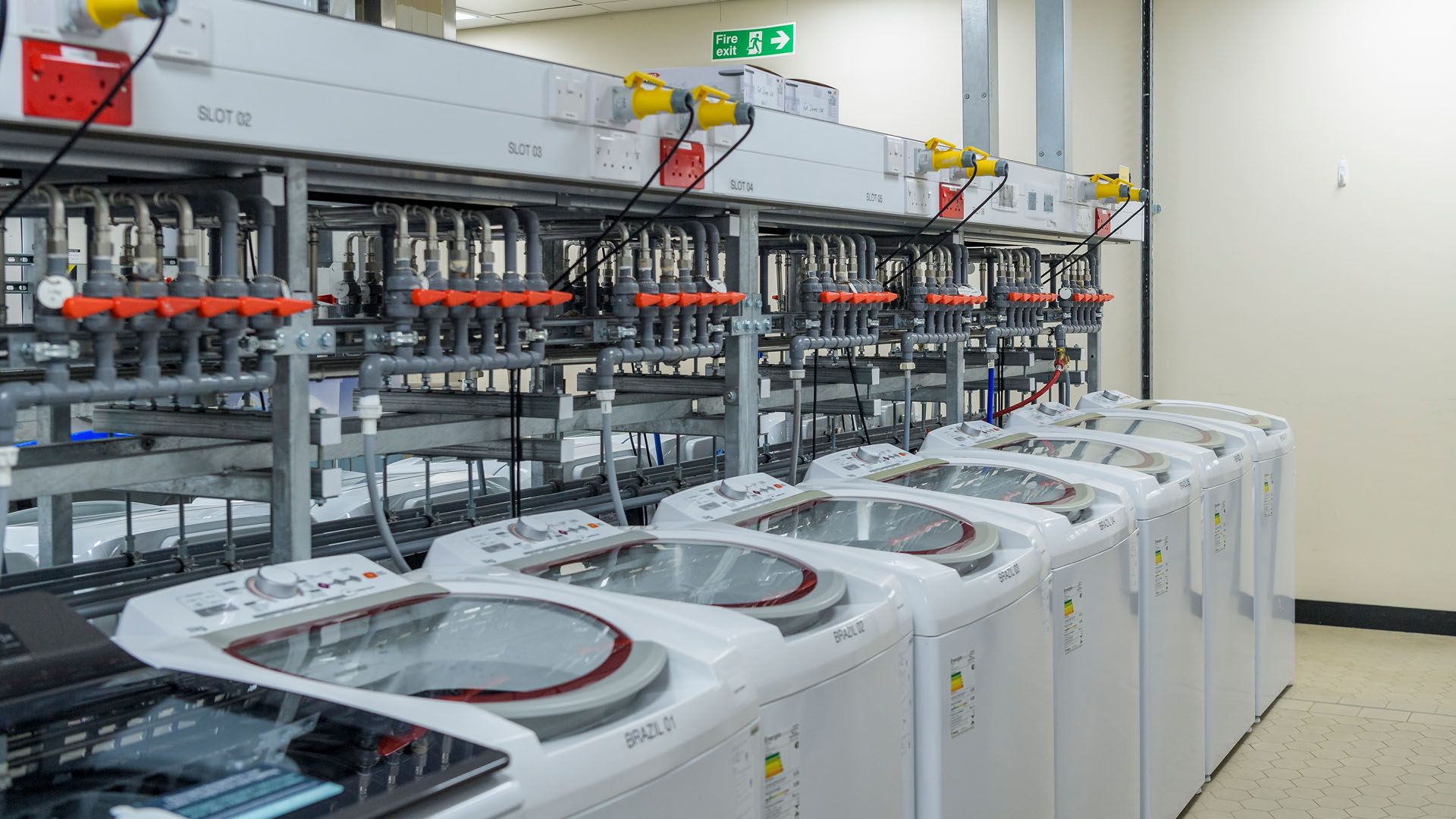 A row of eight top-loading washing machines at Unilever’s laundry detergent testing lab at Port Sunlight in the UK.