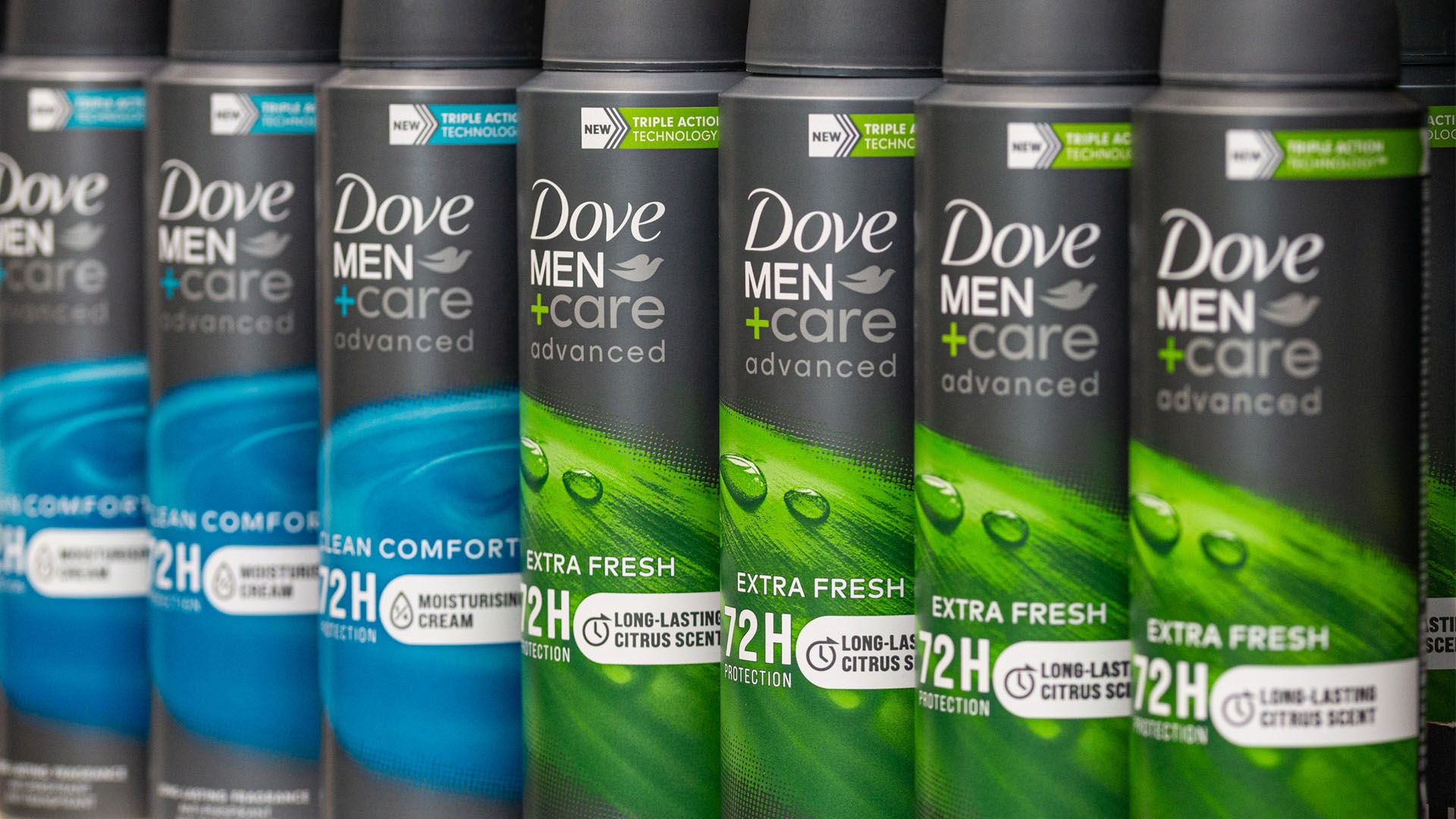 Line of Dove Men+Care 72-hour deodorant cans on supermarket shelf.