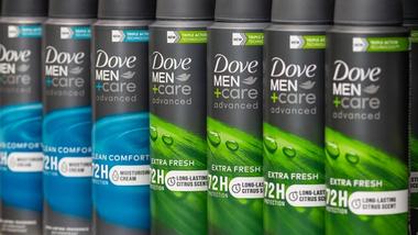 Line of Dove Men+Care 72-hour deodorant cans on supermarket shelf.