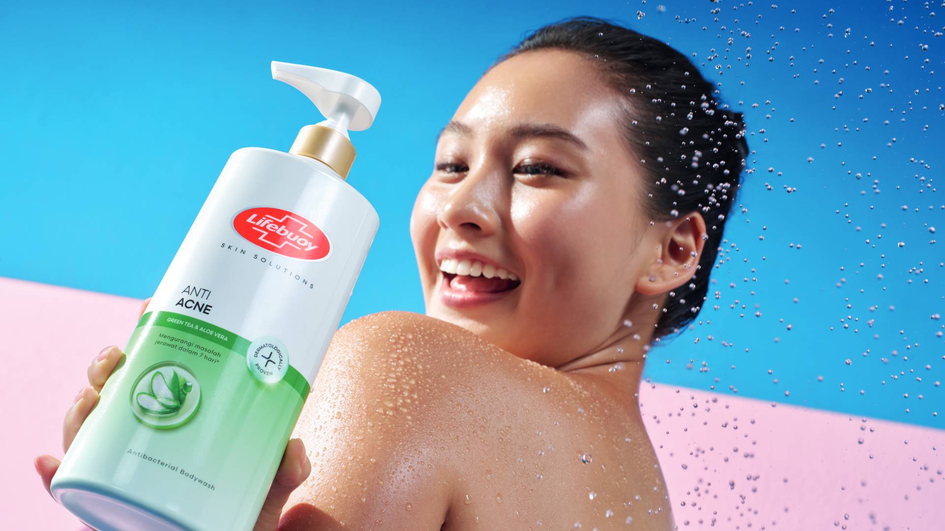 A smiling woman holds Lifebuoy Anti Acne antibacterial body wash -– a white and green bottle with a red Lifebuoy logo. 