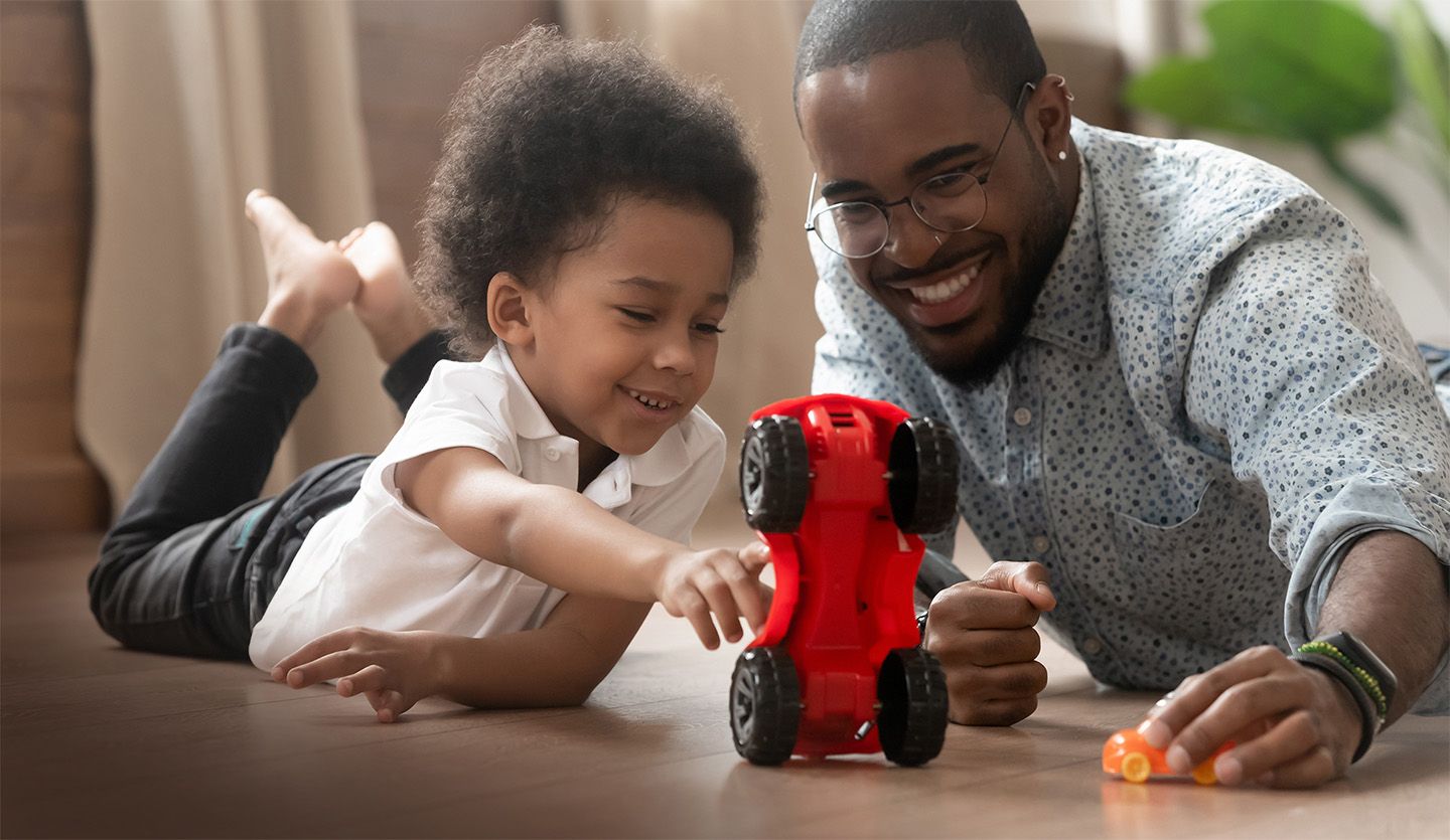 Boy and father playing with toy car